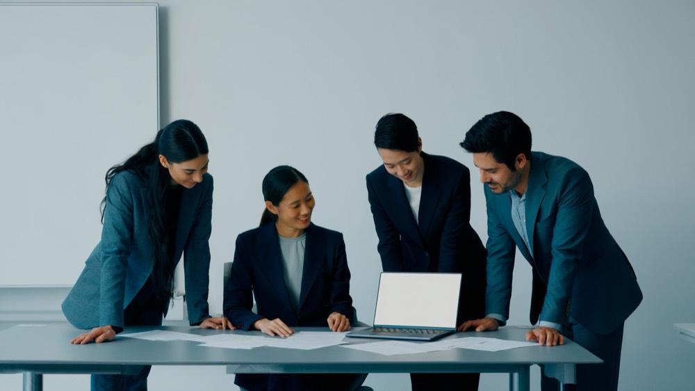 Real estate team gathered around a table reviewing training plans together