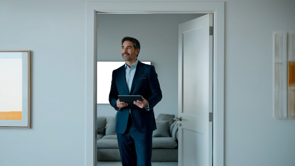Real estate agent welcoming prospective buyers at an open home