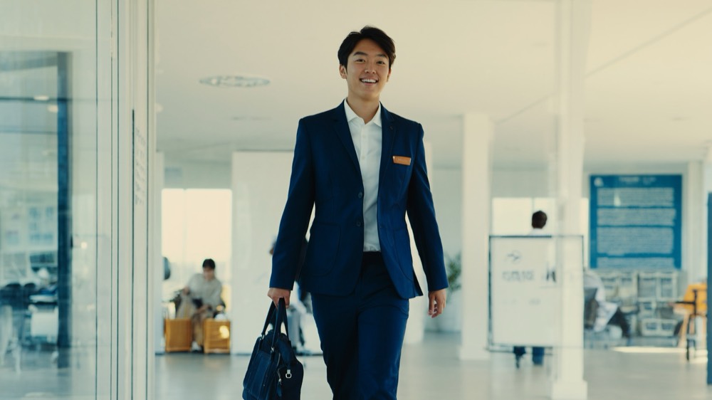 Real estate professional walking up a set of stairs in a modern office, signalling career progression